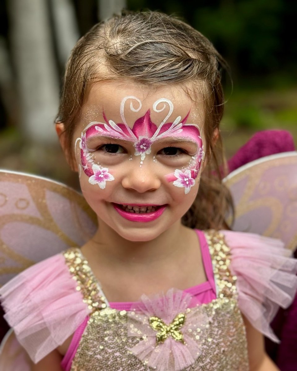 Child in fairy costume with pink floral face painting by Wildflower Face Art